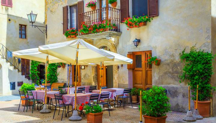 Cozy street cafe and restaurant decorated with colorful flowers, Pienza, Tuscany, Italy, Europe