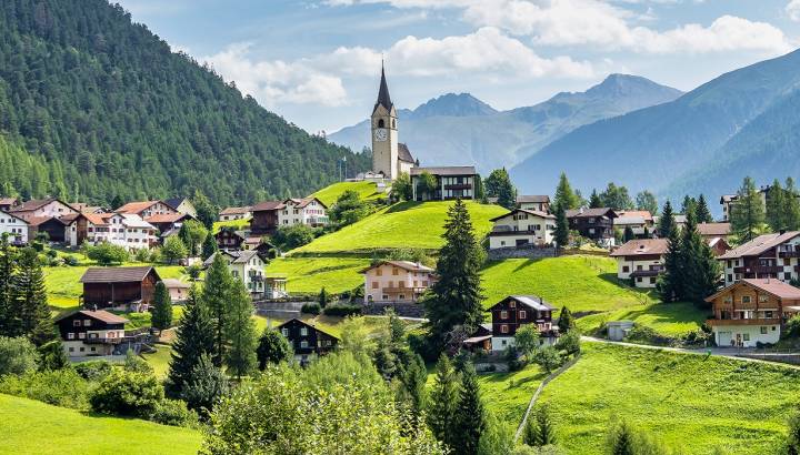 Graubuenden, Switzerland with view of houses on green grassy hills