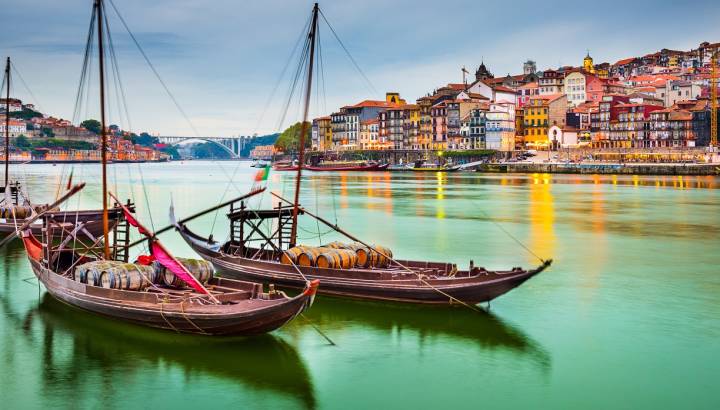 Porto, Portugal old town cityscape on the Douro River with traditional Rabelo boats.