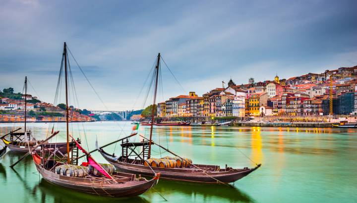 Porto, Portugal old town cityscape on the Douro River with traditional Rabelo boats.
