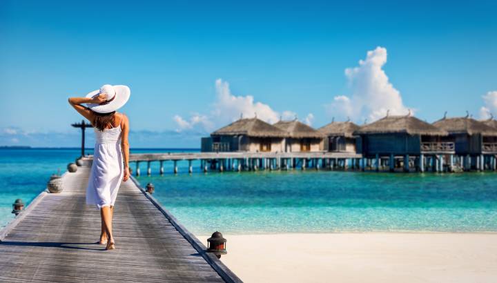 Asian couple enjoying romantic luxury lunch setting at tropical beach in Maldives