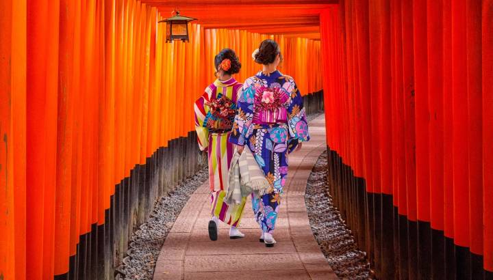 Top 10 temples in Japan - Women in traditional japanese kimonos walking at Fushimi Inari Shrine in Kyoto, Japan
