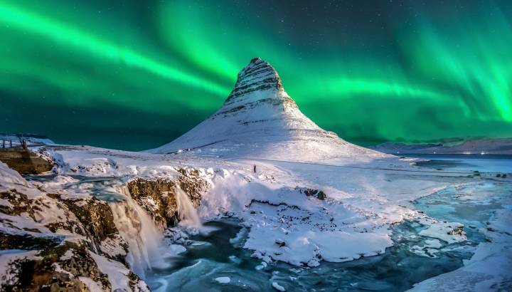northern lights appear over Mount Kirkjufell in Iceland.