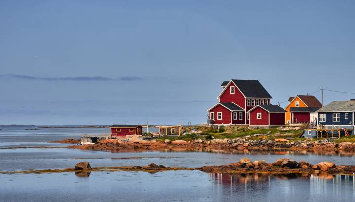 Aufnahme mehrerer roter Holzhäuser an einer Bucht auf Fogo Island, Neufundland und Labrador, Kanada
