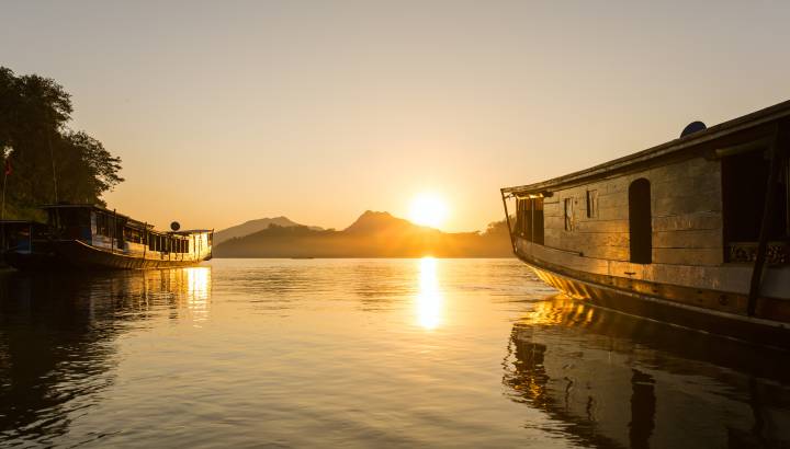 Traditionelle Holzboote auf dem Mekong bei Sonnenuntergang Luang Prabang, Laos