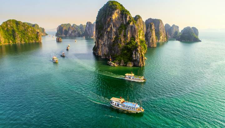 Aerial view floating fishing village and rock island, Halong Bay, Vietnam, Southeast Asia. UNESCO World Heritage Site. Junk boat cruise to Ha Long Bay. Popular landmark, famous destination of Vietnam