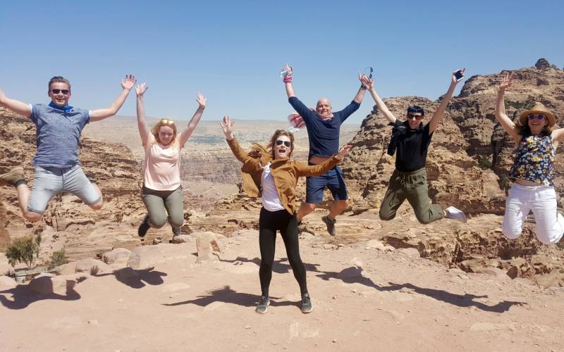 a group of people standing on top of a sandy beach