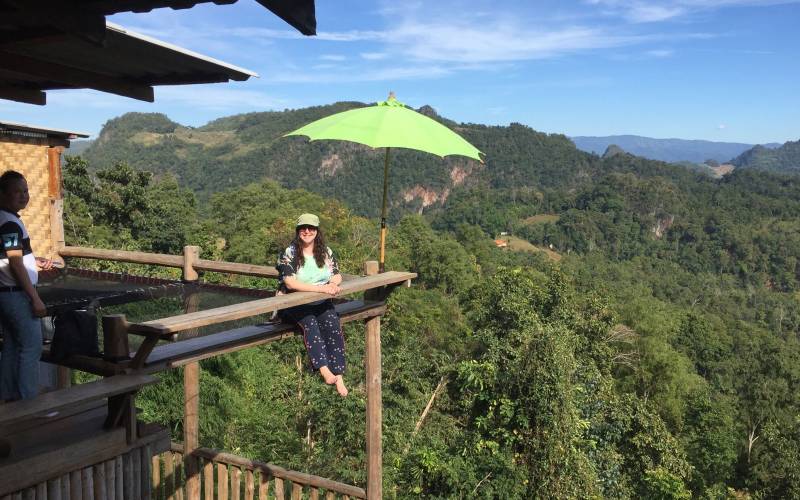 a person sitting on a bench in front of a mountain