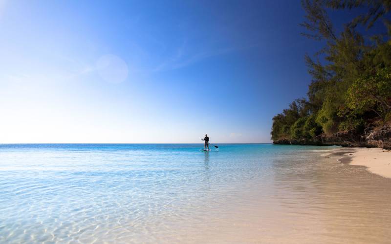 a man standing next to a body of water