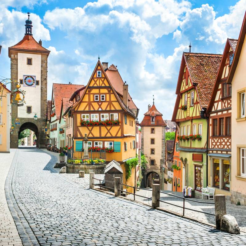 Beautiful postcard view of the famous historic town of Rothenburg ob der Tauber on a sunny day with blue sky and clouds in summer, Franconia, Bavaria, Germany best time to visit Europe