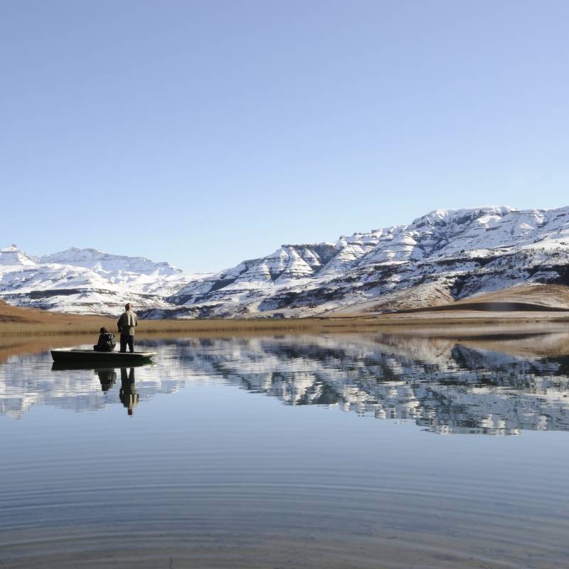 flyfishing for trout against a backdrop of snow at giants cup wilderness reserve, kwazulu natal, south africa - history of South Africa