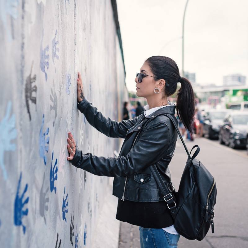 Enchanting Travels Germany Tours Young woman in front of Berlin Wall - German History