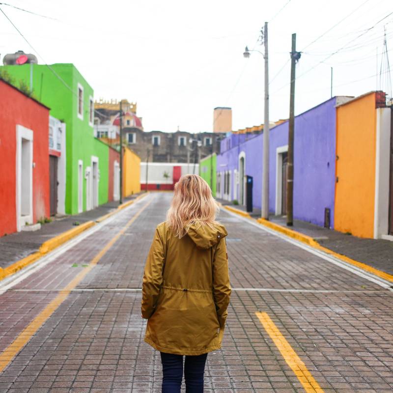 Girl walking up colorful colonial street in Cholula, Mexico