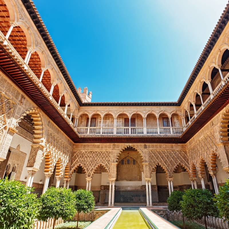 Things to do in Spain - Palace of Alcazar, Famous Andalusian Architecture. Old Arab Palace in Seville, Spain. Ornamented Arch and Column. Famous travel destination.