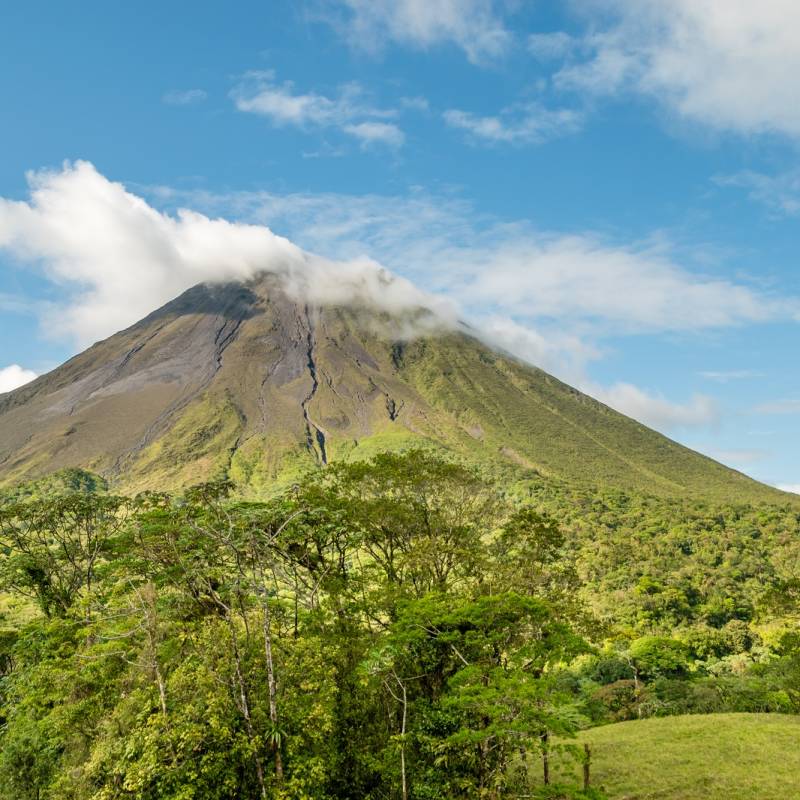 The Arenal volcano surrounded by clouds. This is an active volcano in tropical Costa Rica. The volcano slopes are covered in primary forest full of wildlife.