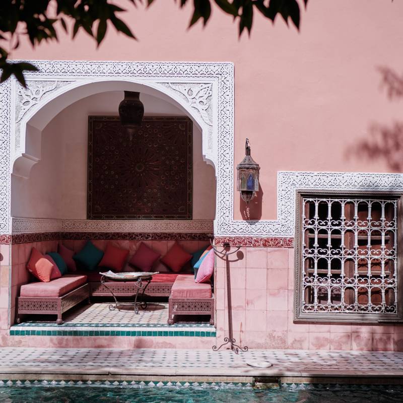 Begrünter Innenhof mit Lounge-Ecke eines Riads in Marokko