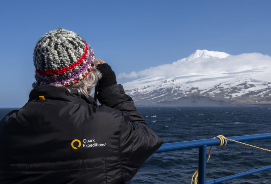 Guest onboard ship looking at Jan Mayen. Photo by Cindy Miller Hopkins. 