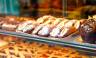 Sweet homemade cannoli stuffed with ricotta cheese cream and pistachial Sicilian dessert at market in Italy