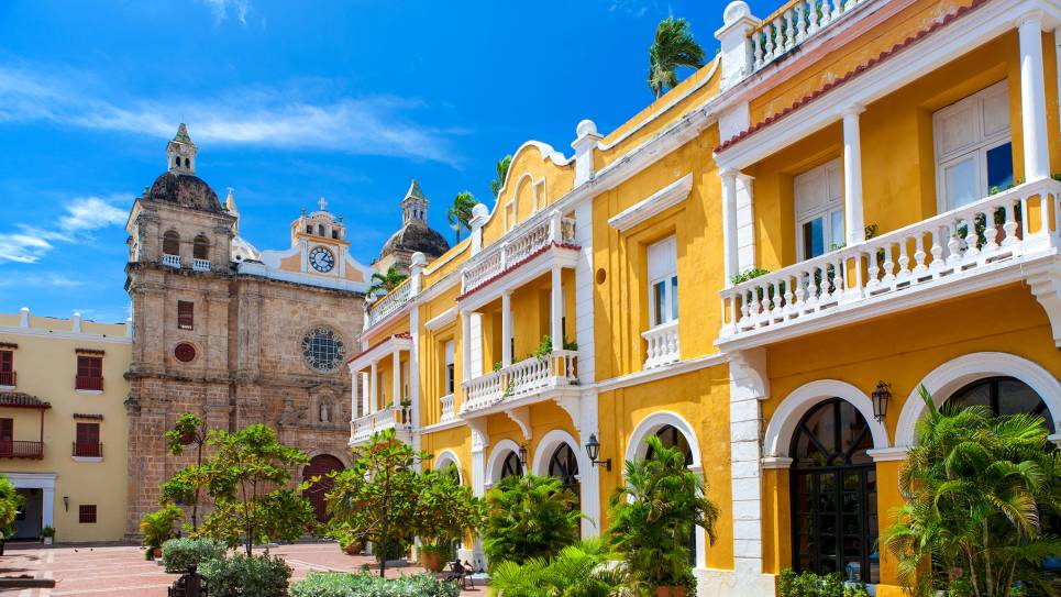 yellow building and church by city square