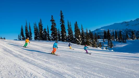 a group of people riding skis on top of a snow covered slope