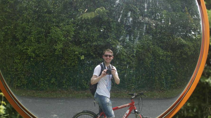 a man riding a bicycle in front of a mirror posing for the camera