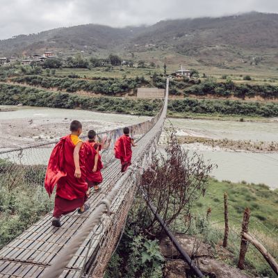 Monks walking over a bridge in Bhutan, Asia