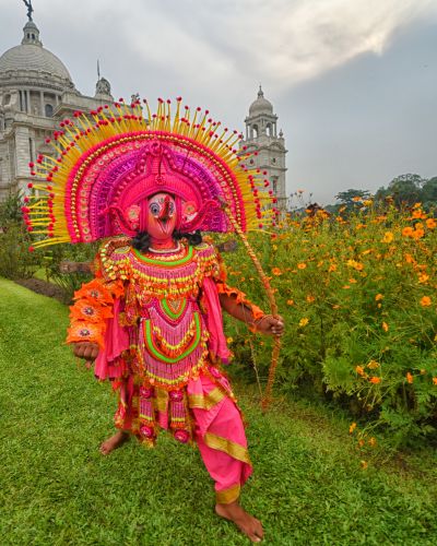 A person in a garment in front of a building with a dome west bengal east India