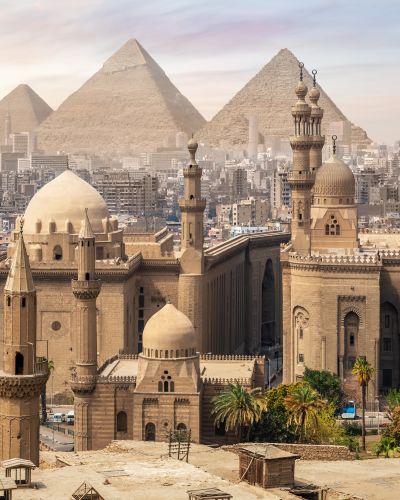 The Mosque of Sultan Hassan and the Great Pyramids of Giza, Cairo skyline, Egypt.