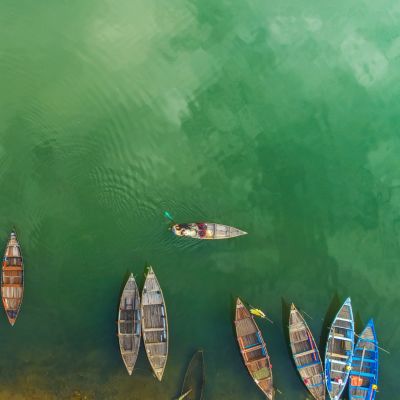 Aerial view or Top view of beautiful clear sea water with colorful long tail boats in the summer of tropical island