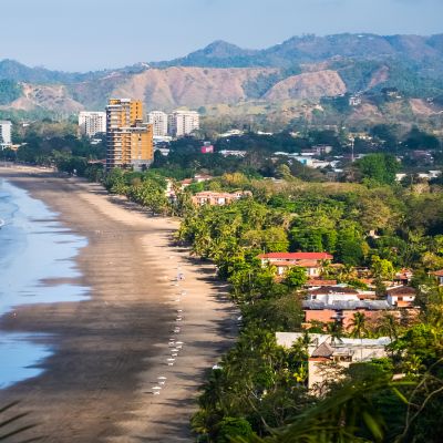 View of morning waves rolling onto the beach on Costa Rica with mountains in the background