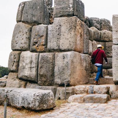 Man entering in front of the huge rocks of Sacsayhuaman in Cusco - Peru, South America