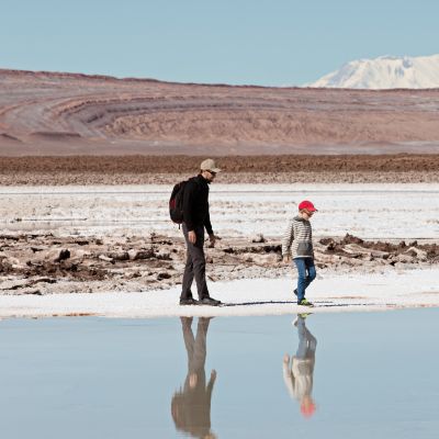 family of two, father and son, hiking and walking together enjoying salty lagunas escondidas in atacama desert, chile, South America