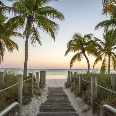 Key West Florida - Famous passage to the beach with palms, sunset and view on the ocean.