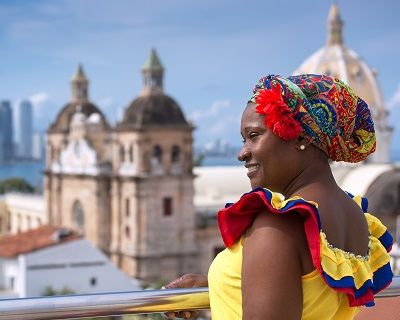 Woman in traditional costume against the backdrop of Cartagena de Indias, Colombia