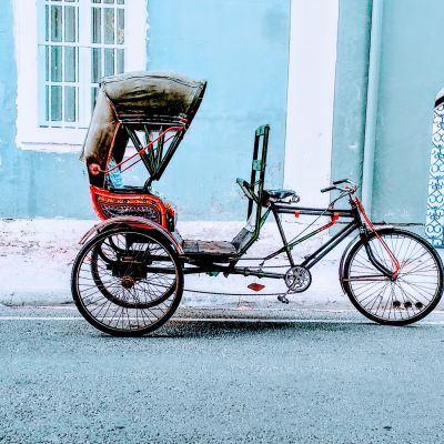 Einsame Rickshaw vor einer himmelblauen Hausfassade in Pondicherry Indien