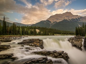 Long exposure of the beautiful Athabasca Falls with towering sunlit of Mount Kerkeslin in the background