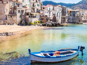 Beautiful old harbor with wooden fishing boat in Cefalu, Sicily, Italy.