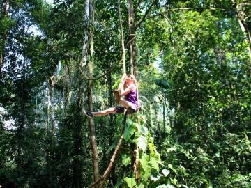 Girl swinging in the trees, Amazon, Peru