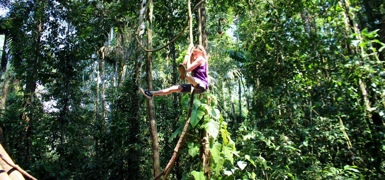 Girl swinging in the trees, Amazon, Peru