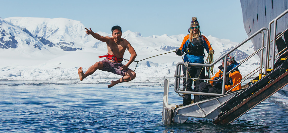 A guest jumps off the gangway (with a safety harness) into Antarctic waters during the Polar Plunge.