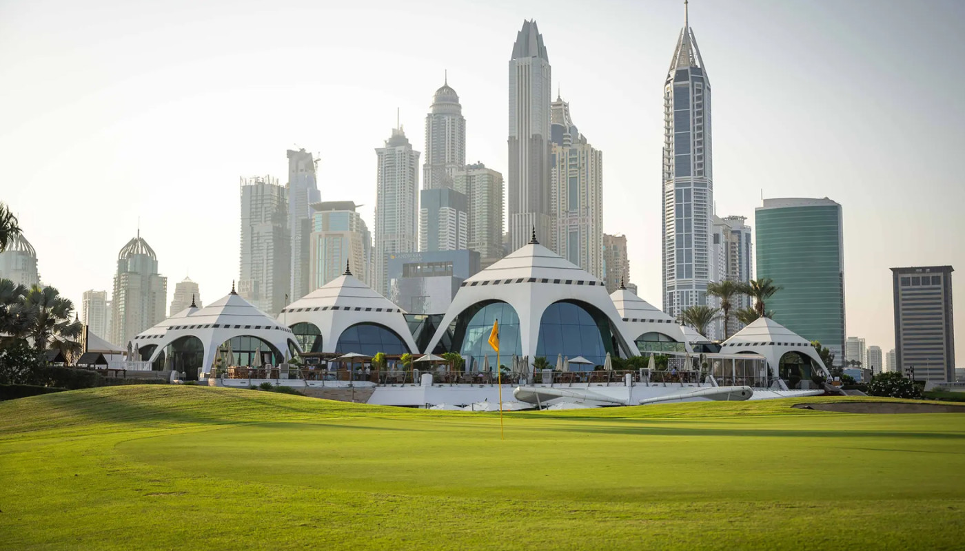 The futuristic clubhouse at Emirates Golf Club with the Dubai skyline in the background.