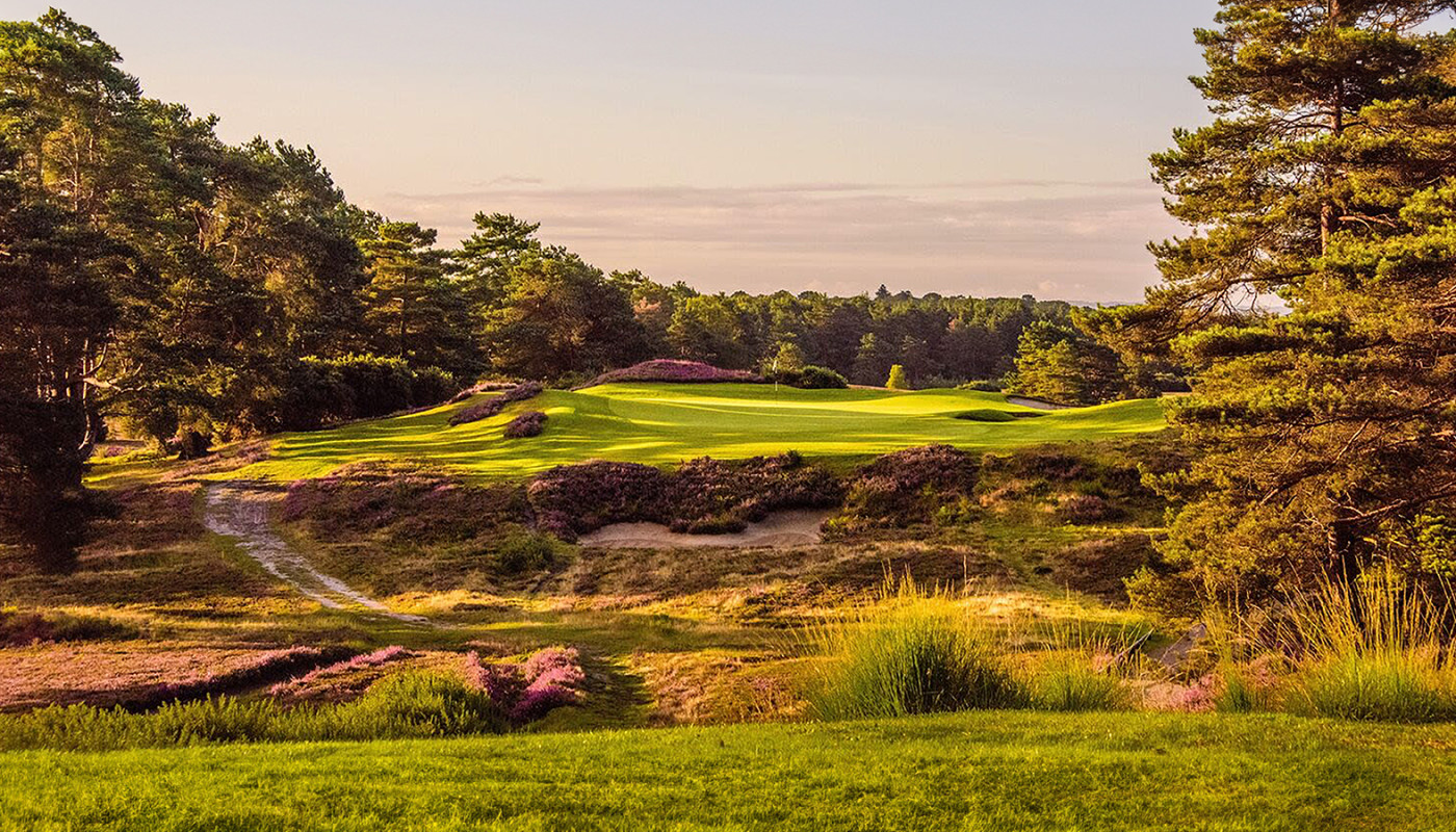 Bunkers and flowers along a fairway leading to the green of the Old Course at Sunningdale Golf Club in Ascot, England.