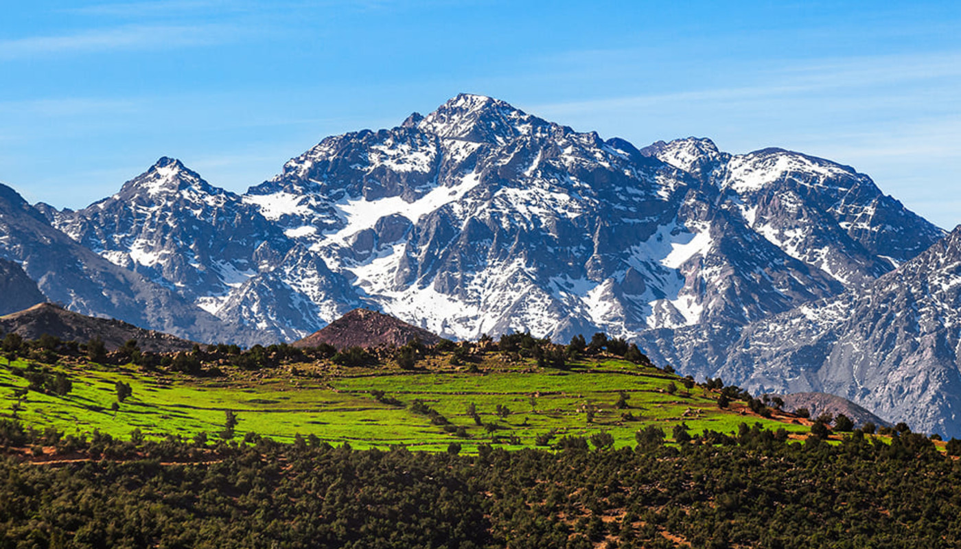 The Atlas Mountain range stands out against a bright blue sky.