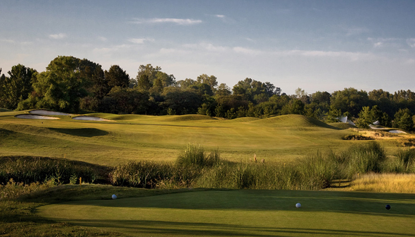 The tee box view of an uphill fairway under blue sky at Buenos Aires Golf Club in Buenos Aires, Argentina.