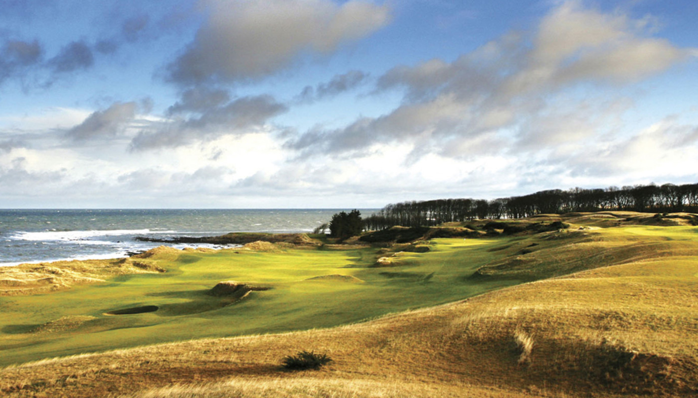 Kingsbarns Golf Links along the rocky shore of the Irish Sea under a cloud-streaked sky in Newcastle, Northern Ireland.