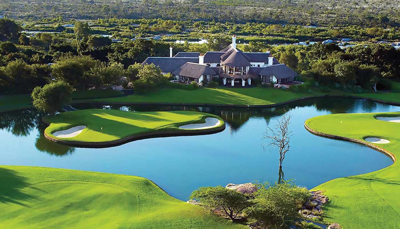 An aerial shot of the 18th hole island green in front of the clubhouse at Leopard Creek Golf Club in Malalane, South Africa.