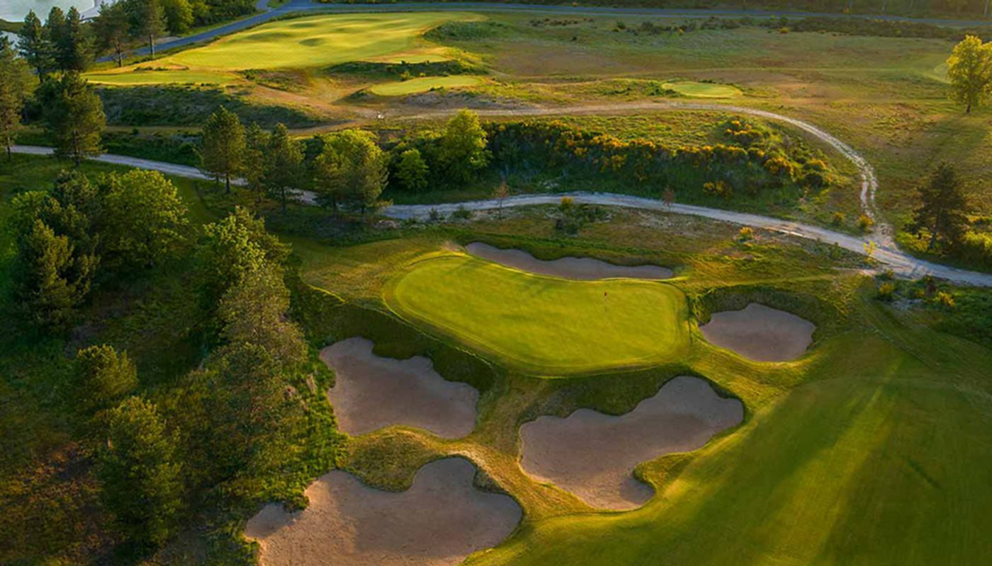 An aerial view of a green surrounded by large bunkers and trees a Les Bordes Golf Club in Saint-Laurent-Nouan, France.