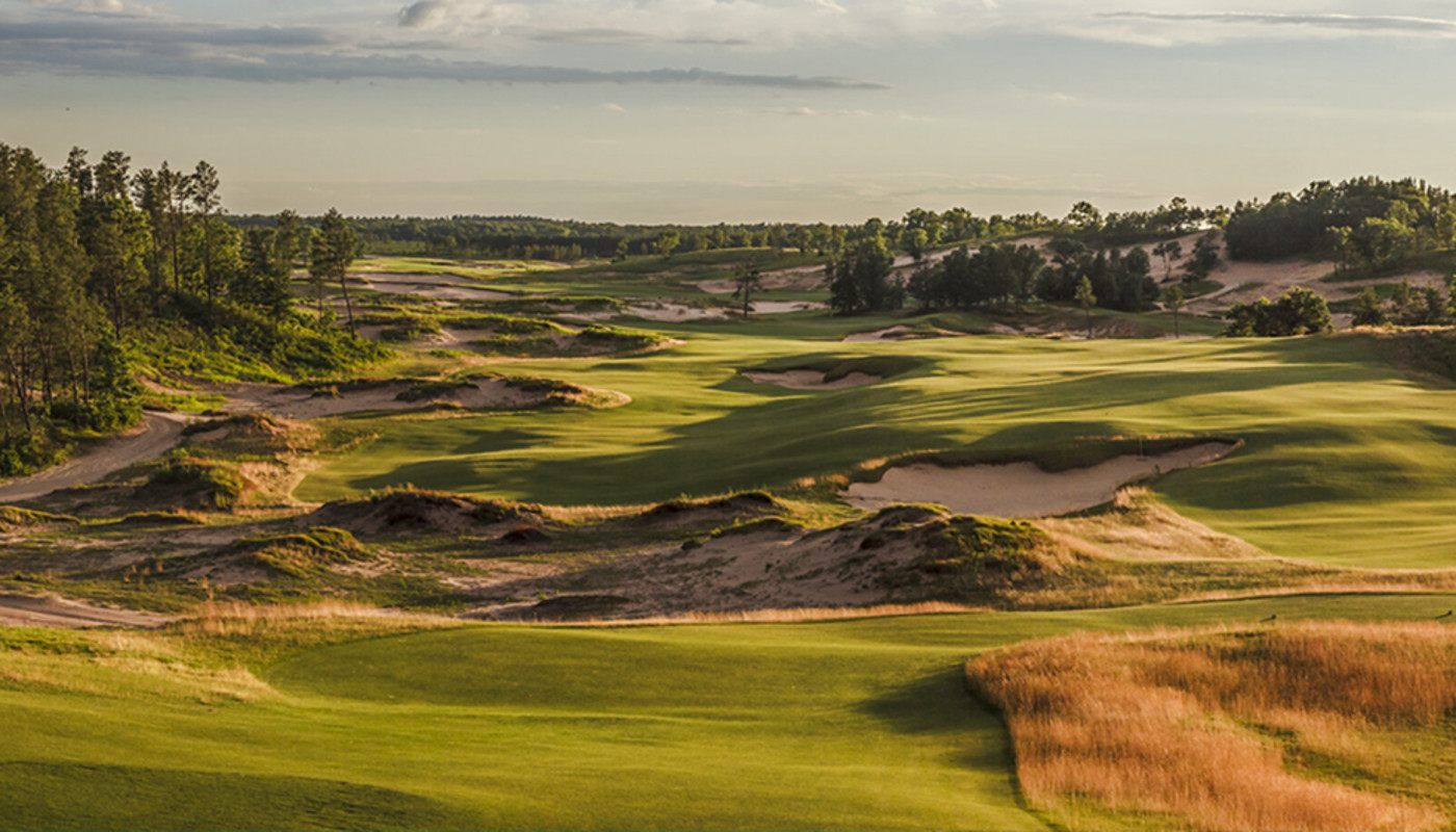 A sloping hole at Bandon Dunes Golf Resort runs alongside massive dunes and the coast of the Pacific Ocean in Bandon, Oregon.