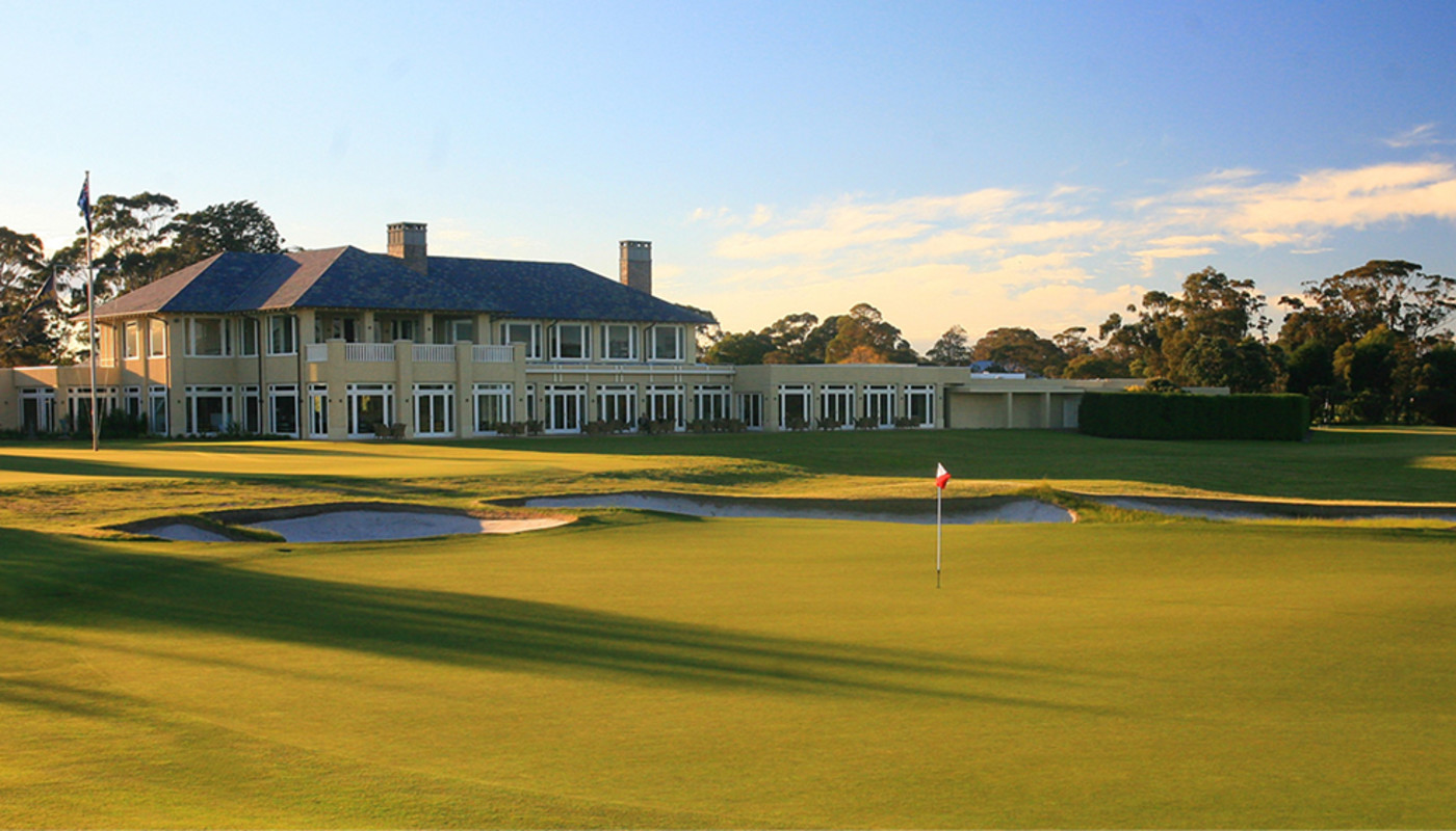 A contoured green rests under warm light before the clubhouse at Royal Melbourne Golf Club just outside of Melbourne, Australia.