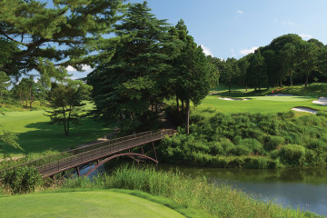 A bridge crosses over a lake, leading to the 12th green on the West Course at Yokohama Country Club outside of Tokyo, Japan.